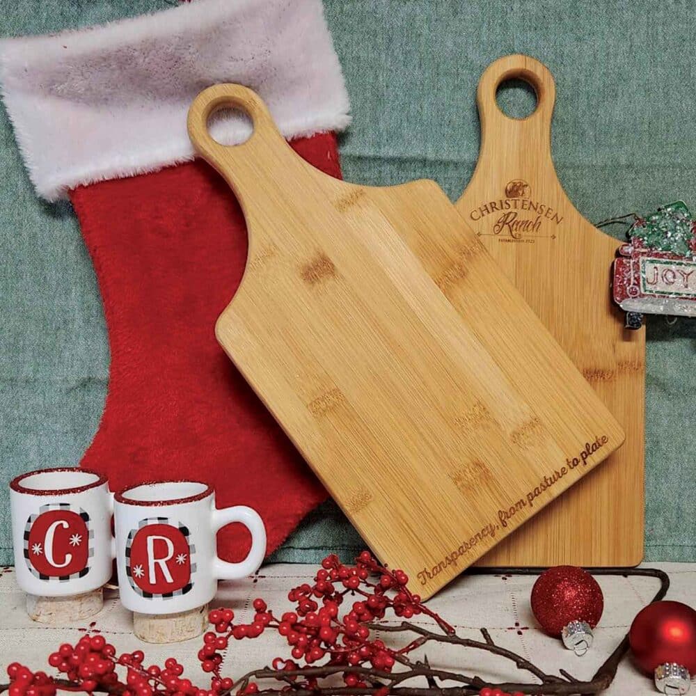 Two custom engraved charcuterie boards with assorted holiday decorations