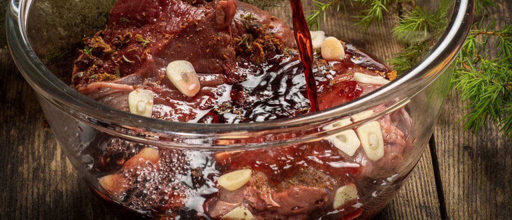 Beef and marinade with garlic in a glass bowl