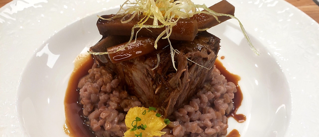 Christensen Ranch braised short ribs with farro risotto, orange gremolata, and espresso roasted parsnips at PARC Aspen