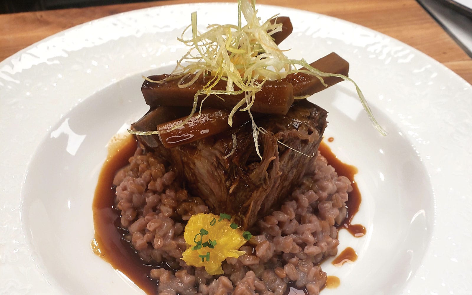 Christensen Ranch braised short ribs with farro risotto, orange gremolata, and espresso roasted parsnips at PARC ASPEN