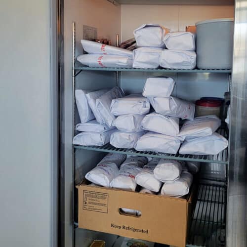 Freezer filled with paper-wrapped cuts of beef from a Custom Quarter Beef Share order